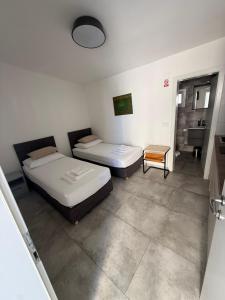 a room with two beds and a table at Apartmani Lovren in Novalja +42 photos
