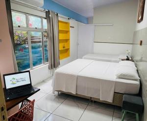 a bedroom with a bed and a laptop on a desk at Residência Ilha Bela - Casa Inteira no Centro Histórico de São Luís in São Luís