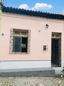 a white building with two windows and a door at Residência Ilha Bela - Casa Inteira no Centro Histórico de São Luís in São Luís
