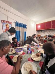 a group of people sitting around a table eating food at Dawaipani Sona Homestay in Jālāpahār +20 photos