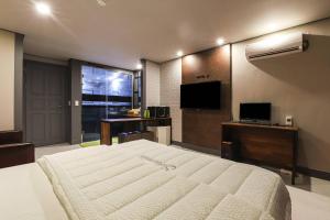 a bedroom with a large bed and a television at 세븐호텔 in Daegu +20 photos
