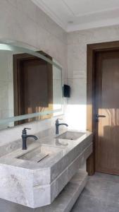 a bathroom with two sinks and a large mirror at شاليه بيسان 2 in Jeddah +5 photos
