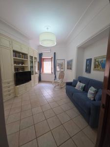 a living room with a blue couch and a tv at 2Steps Capri - central holiday house in Capri