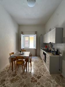 a kitchen with a table and chairs in a kitchen at Residence Prato in Trapani +55 photos
