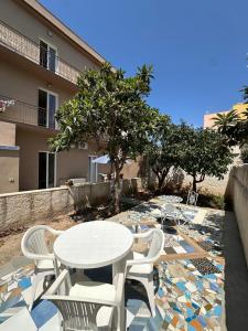 a patio with a table and chairs and a building at Residence Prato in Trapani
