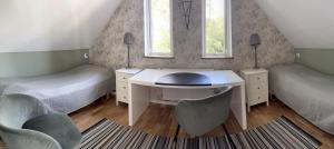 ein Schlafzimmer mit zwei Betten und einem Schreibtisch und zwei Stühlen in der Unterkunft Kullsbacka in Skanör med Falsterbo