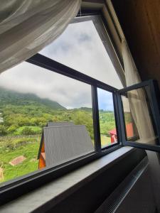 a window with a view of a house at Villa Okatse in Zeda-Gordi