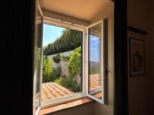 a window in a room with a view of a garden at Edera Rooms in Tolfa