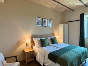 a bedroom with a bed and a chair at Edera Rooms in Tolfa +16 photos