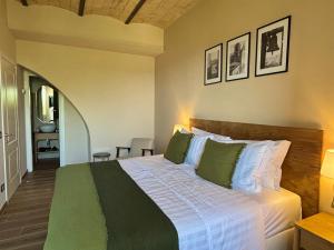 a bedroom with a large bed with green pillows at Edera Rooms in Tolfa
