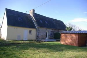 ein weißes Haus mit einem schwarzen Dach und einer Garage in der Unterkunft Gîte Caribou in Céaux