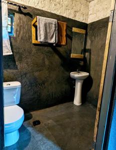 a bathroom with a toilet and a sink at Alkebulan cottages in Uru +14 photos