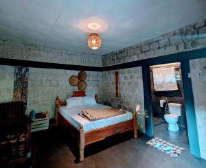 a bedroom with a bed and a bathroom at Alkebulan cottages in Uru