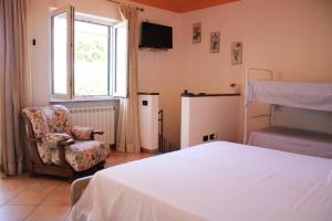 a bedroom with a bed and a chair and a window at Appartamento Mura in Forio d'Ischia