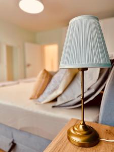 a lamp sitting on a table in front of a bed at Central Apartment in Kyustendil