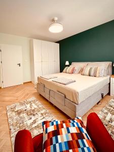 a bedroom with a large bed and a green wall at Central Apartment in Kyustendil