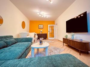 a living room with a couch and a flat screen tv at Central Apartment in Kyustendil
