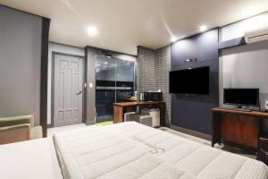 a bedroom with a bed and a flat screen tv at 세븐호텔 in Daegu