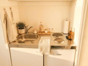 a small kitchen with a sink and a stove at GLORYSTAY - Business Studio-Bosch Campus 2km-Tiefgarage-Workspace-Renningen in Renningen +13 photos