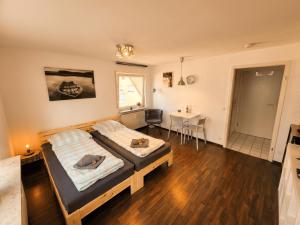 a bedroom with two beds and a table in it at GLORYSTAY - Business Studio-Bosch Campus 2km-Tiefgarage-Workspace-Renningen in Renningen