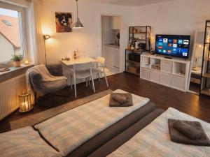 a living room with a table and a tv at GLORYSTAY - Business Studio-Bosch Campus 2km-Tiefgarage-Workspace-Renningen in Renningen
