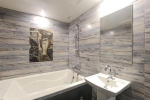 a bathroom with a tub and a sink and a bath tub at 세븐호텔 in Daegu