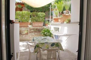 a table and chairs on a patio with plants at Appartamento Mura in Forio d'Ischia
