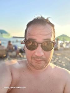 ein Mann mit Sonnenbrille am Strand in der Unterkunft Riyadh palms in Constantine