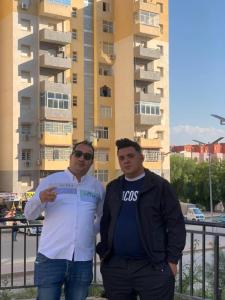 Zwei Männer stehen vor einem Gebäude in der Unterkunft Riyadh palms in Constantine