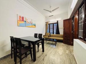 a dining room with a table and chairs and a couch at Fort Grande ONE in Cochin +47 photos