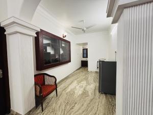a living room with a chair and a refrigerator at Fort Grande ONE in Cochin