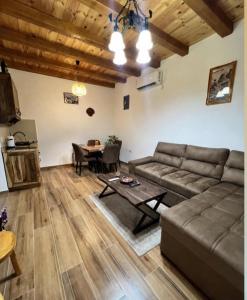 a living room with a couch and a table at Small Stone Cottage in Virpazar