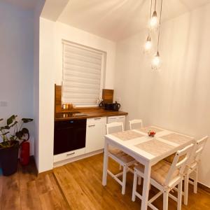 a kitchen and dining room with a white table and chairs at Argent apartman in Balatonmáriafürdő +4 photos