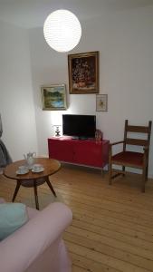 sala de estar con sofá, mesa y TV en BellaCaro, en Löhne