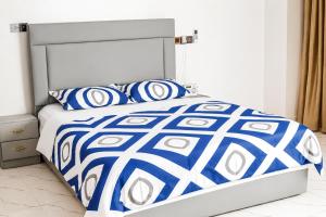 a bed with blue and white sheets and pillows at Kingdom homes in Amanfro