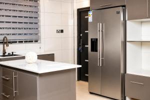 a kitchen with a stainless steel refrigerator and a counter at Kingdom homes in Amanfro