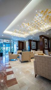 a hotel lobby with couches and a chandelier at Shaheen Hotel Baghdad in Baghdād