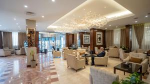 a lobby of a hotel with a man sitting in a chair at Shaheen Hotel Baghdad in Baghdād +130 photos