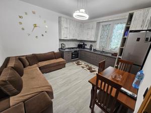 a living room with a couch and a table and a kitchen at Vila Elbasan in Labinot i Poshtëm