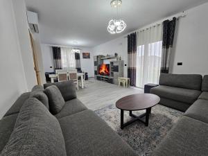 a living room with a couch and a table and a fireplace at Vila Elbasan in Labinot i Poshtëm +8 photos