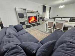 a living room with a blue couch and a fireplace at Vila Elbasan in Labinot i Poshtëm
