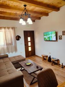 a living room with a couch and a table at Small Stone Cottage in Virpazar