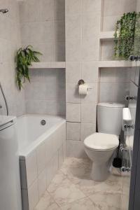 a bathroom with a toilet and a tub and a sink at Apartament nad Soliną in Polańczyk