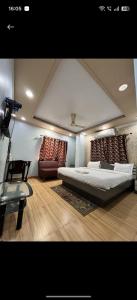 a bedroom with a large bed and a chair at hotel darbar international in Gaya