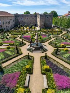 a garden in front of a castle with a fountain at ICOSIUM Hostel in Braga