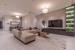 un soggiorno con un divano e una TV a schermo piatto di Amber Hospitality - Qurtubah a Riyad