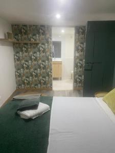 a bedroom with a white bed and a green wall at maison de village in Alairac