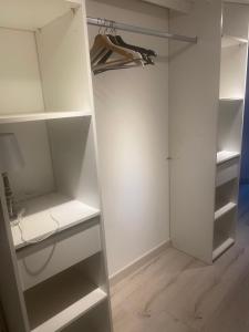a white walk in closet with white shelves at maison de village in Alairac +1 photo