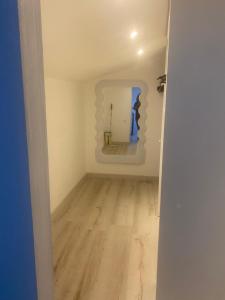 an empty room with a mirror and a wooden floor at maison de village in Alairac
