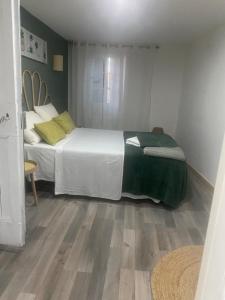a bedroom with a bed with white sheets and yellow pillows at maison de village in Alairac
